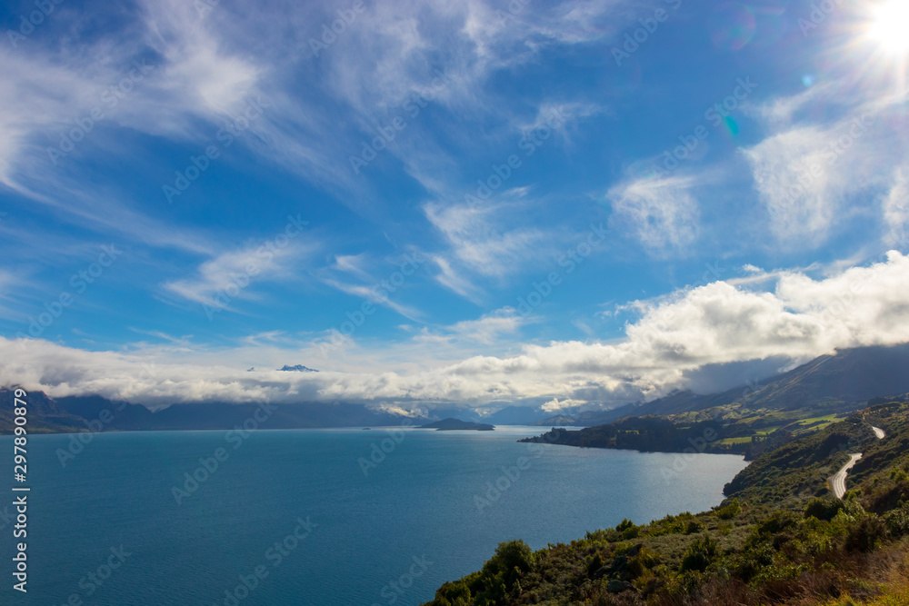 Blue Sky and CLouds over Lake with Wooded Road New Zealand Blue Sky and CLouds over Lake with Wooded Road New Zealand