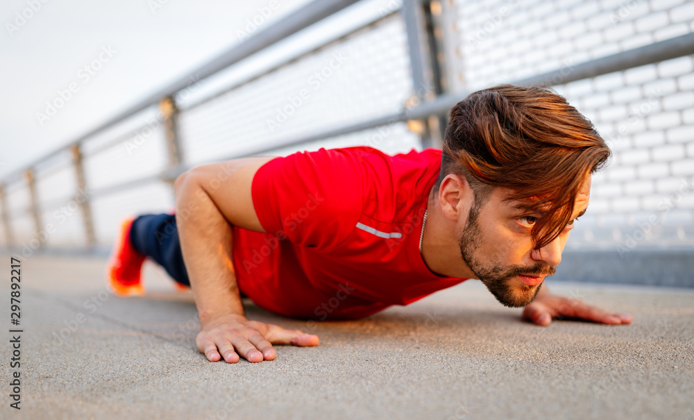 Fototapeta premium Handsome fit man warming up before jogging outdoor
