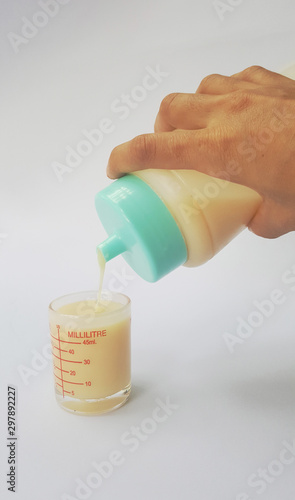 hand with bottle of condensed milk isolated on white