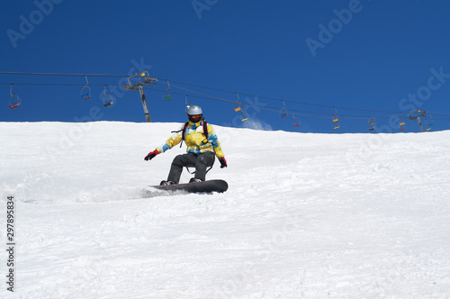 Snowboarder descends on snowy ski slope at winter mountain
