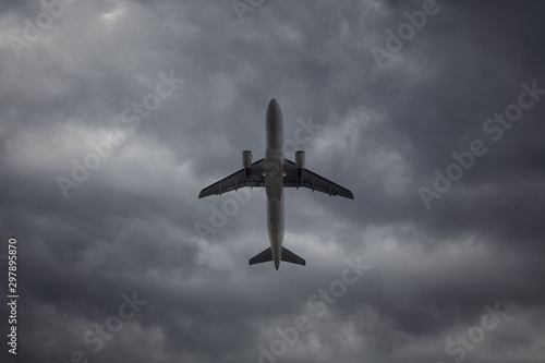 A passenger plane in the cloudy sky. Commercial plane taking off on background of storm clouds, turbulence concept.