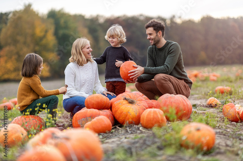 Photos Happy young family in pumpkin patch field