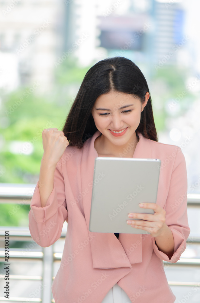 beautiful young Asian woman using a tablet.