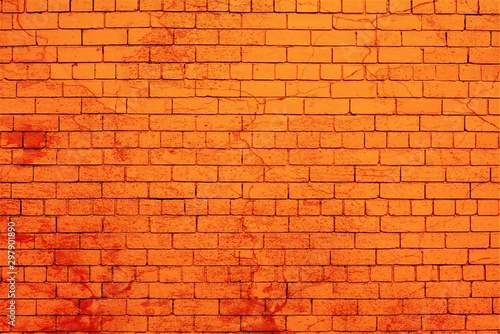 Brick wall painted in orange color splashed with red paint.
