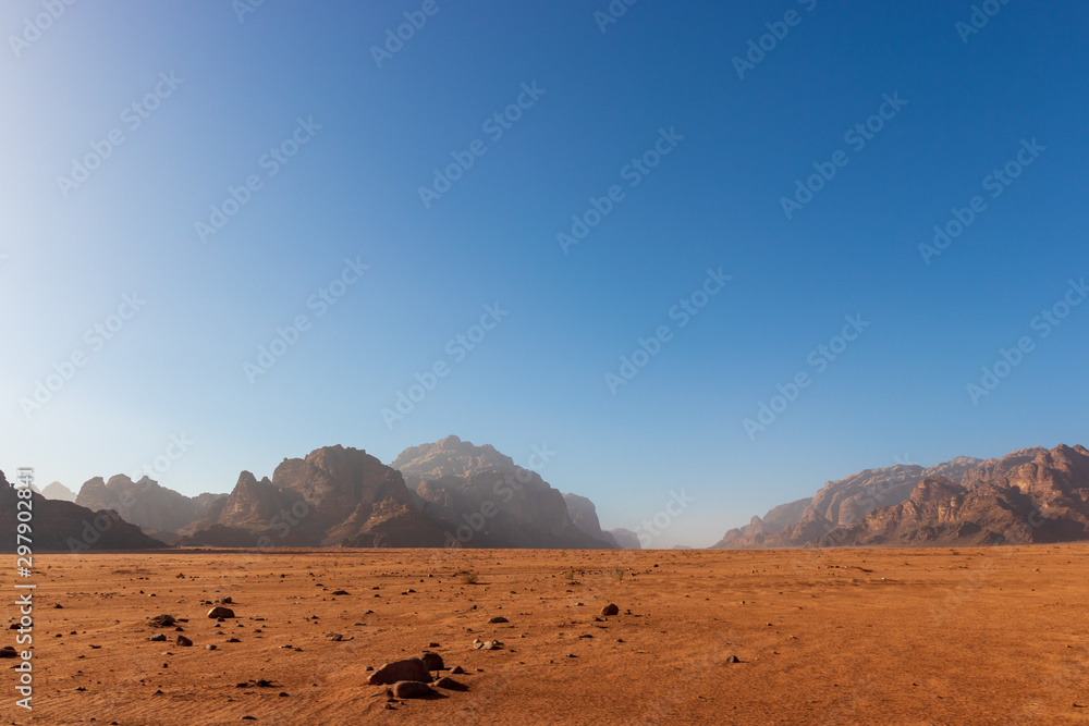 View of desert plain at Wadi Rum, Jordan with blue sky and mountain background