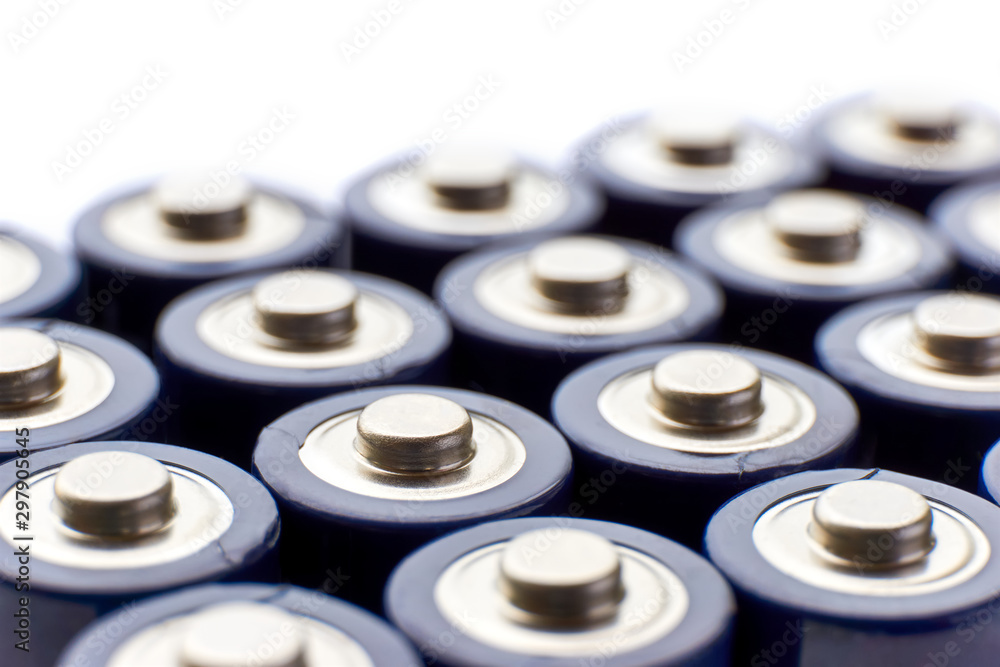 Batteries in rows. Close-up or macro of the positive poles of blue alkaline AA batteries. Image with selective focus isolated on top for copy space. Batteries in rows. Close-up or macro of the positive poles of blue alkaline AA batteries. Image with selective focus isolated on top for copy space.