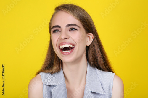 Young laughing girl on yellow background