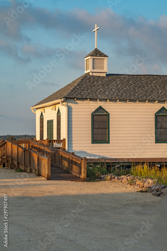 Local chapel in the early morning sunlight sits over a marshy creek