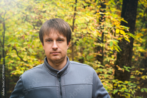 Portrait of young courageous man in autumn forest