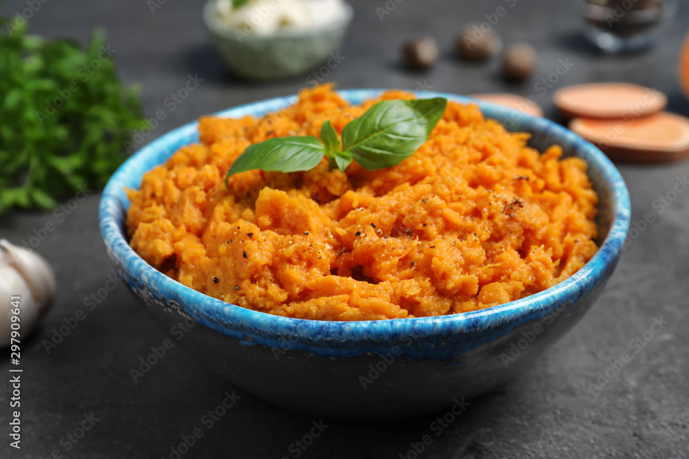 Bowl of tasty sweet potato puree on grey table Bowl of tasty sweet potato puree on grey table