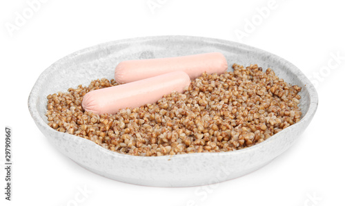 Delicious buckwheat porridge with sausages on white background