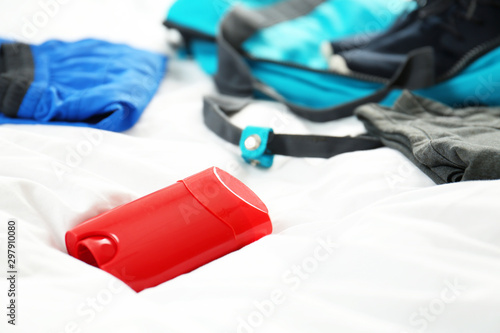 Deodorant and gym clothes on white fabric, closeup