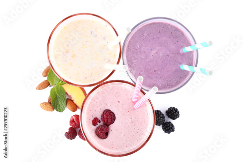 Different fresh tasty milk shakes in glasses with ingredients on white background, top view