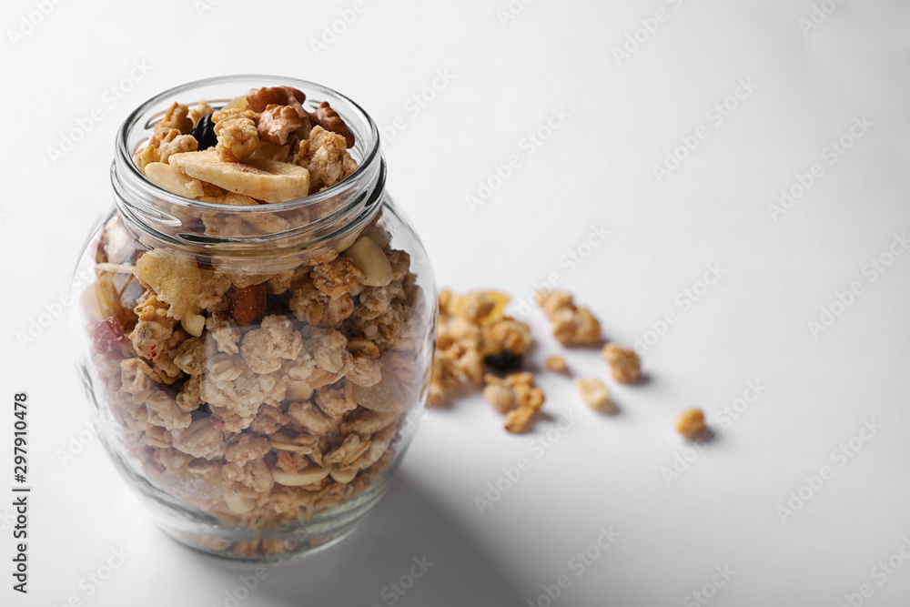 Jar of tasty homemade granola on white background. Healthy breakfast Jar of tasty homemade granola on white background. Healthy breakfast