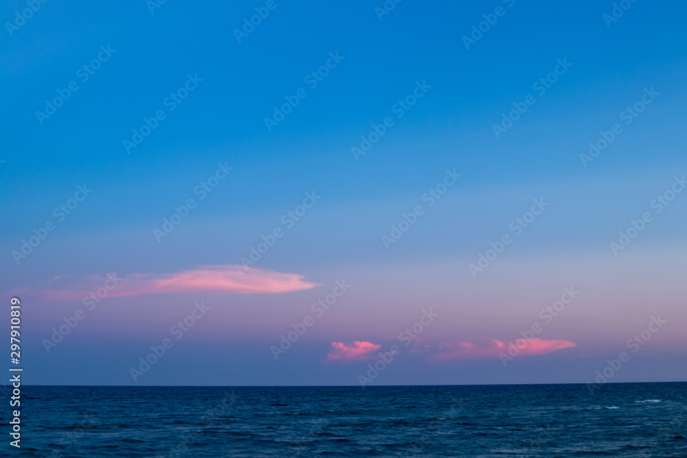 Sunset hour at Palm Beach, FL looking out at the ocean  with  pink clouds