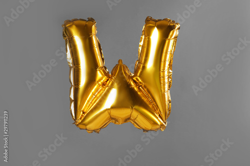 Golden letter W balloon on grey background