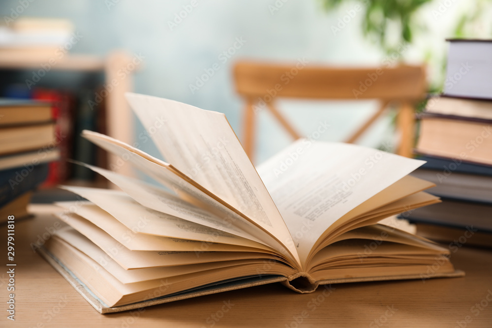 Open hardcover book on wooden table indoors Open hardcover book on wooden table indoors