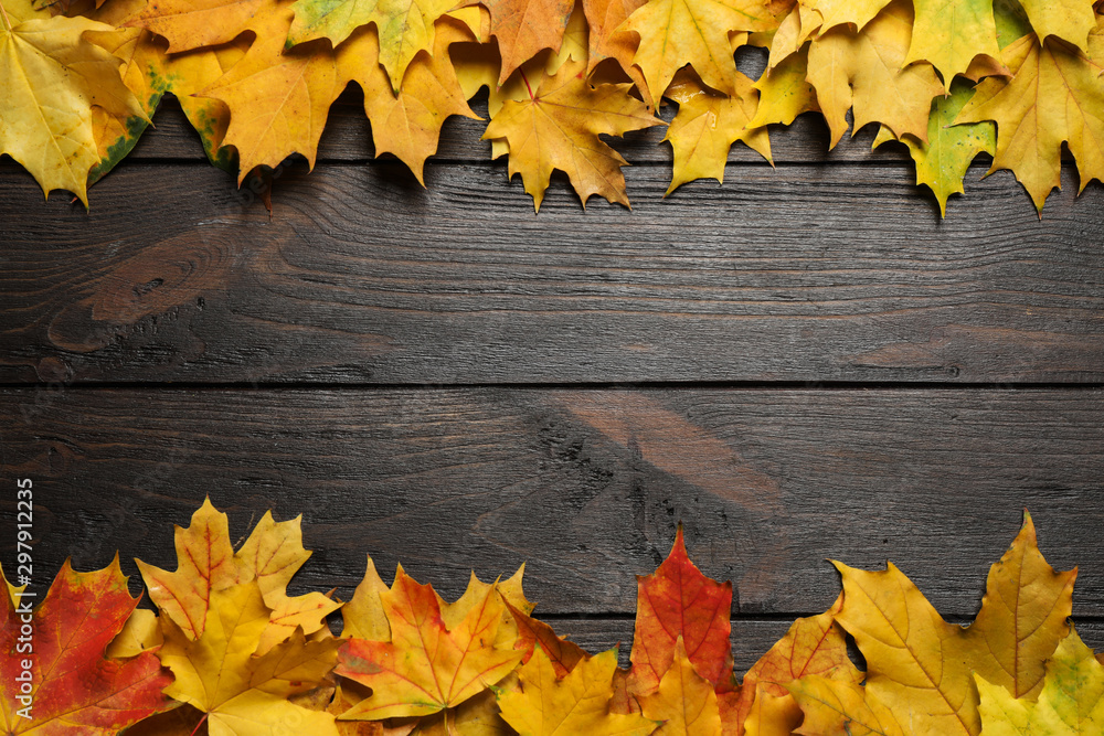 Frame made of autumn leaves on dark wooden table, flat lay. Space for text Frame made of autumn leaves on dark wooden table, flat lay. Space for text