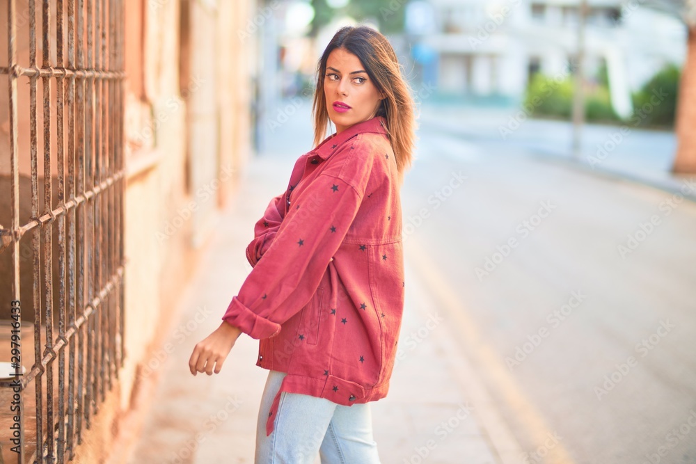 Young beautiful woman wearing red jacket standing at the town street Young beautiful woman wearing red jacket standing at the town street