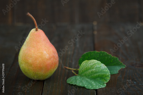 Fresh pear with leaves on wooden background. Organic pear, sweet and healthy fruit.