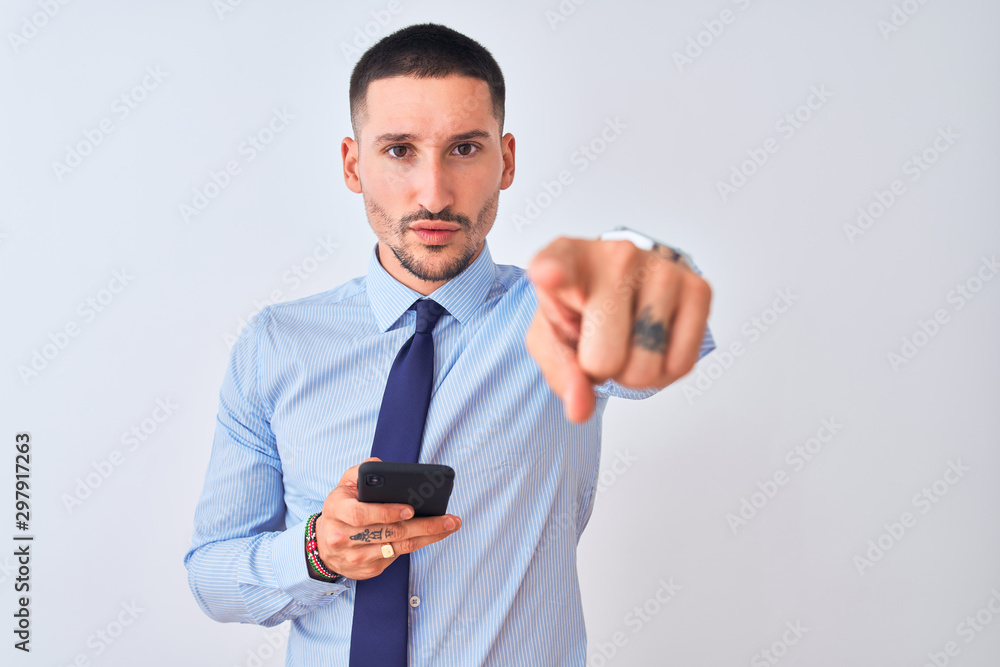 Young handsome business man using smartphone over isolated background pointing with finger to the camera and to you, hand sign, positive and confident gesture from the front Young handsome business man using smartphone over isolated background pointing with finger to the camera and to you, hand sign, positive and confident gesture from the front