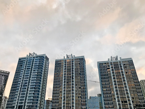 Tall beautiful monolithic-frame panel buildings, new buildings, skyscrapers, houses made of glass and concrete with many windows in the new district of the city. The background