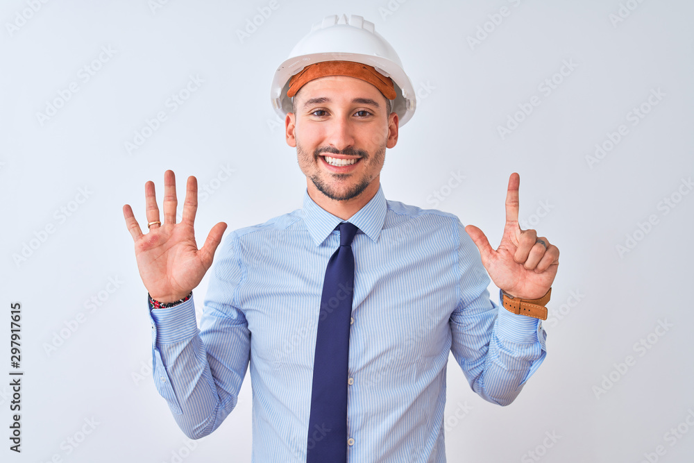 Young business man wearing contractor safety helmet over isolated background showing and pointing up with fingers number seven while smiling confident and happy. Young business man wearing contractor safety helmet over isolated background showing and pointing up with fingers number seven while smiling confident and happy.