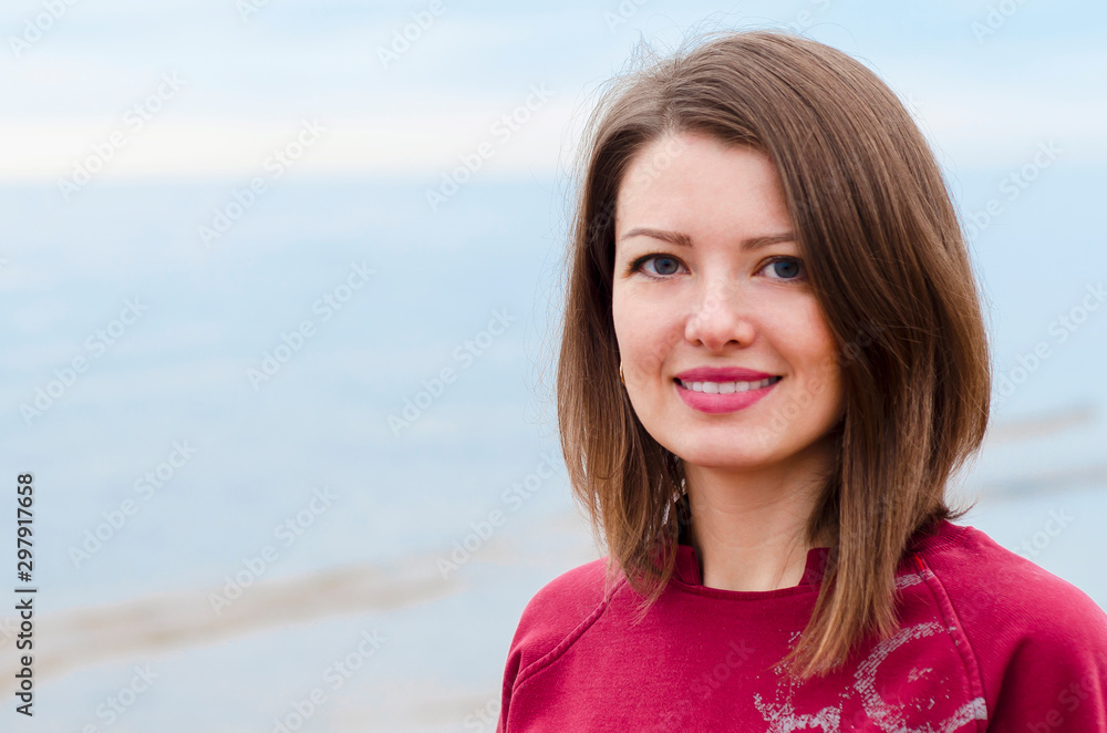 portrait of a young happy girl with a beautiful smile on the seashore outdoors. portrait of a young happy girl with a beautiful smile on the seashore outdoors.