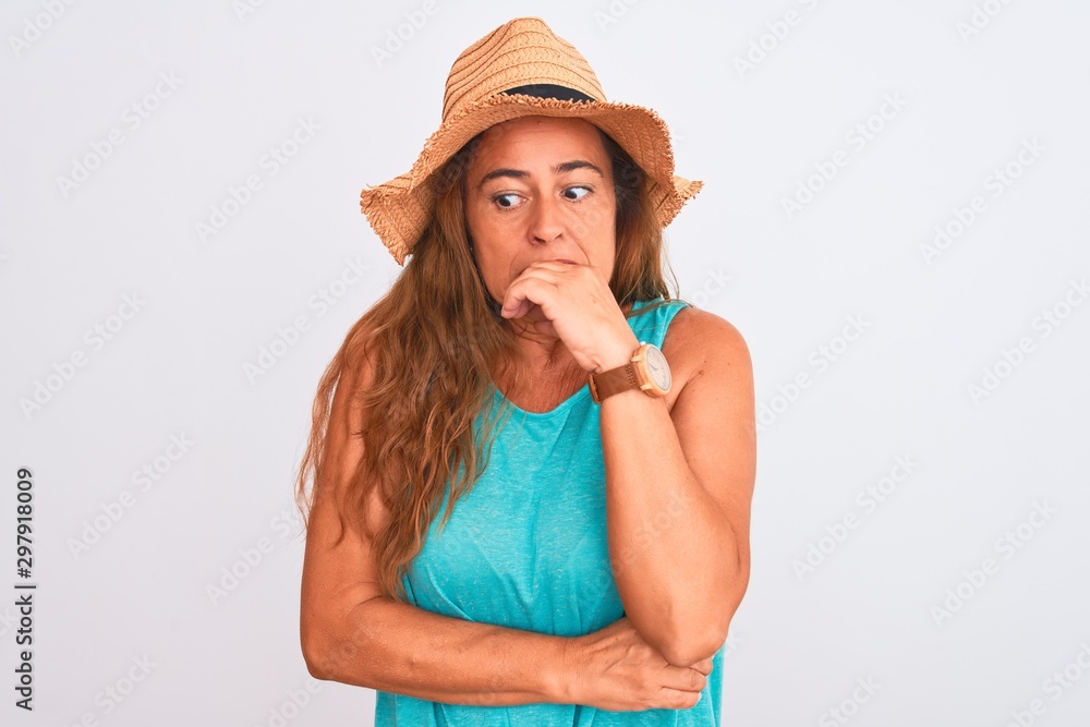 Middle age mature woman wearing summer hat over white isolated background looking stressed and nervous with hands on mouth biting nails. Anxiety problem.