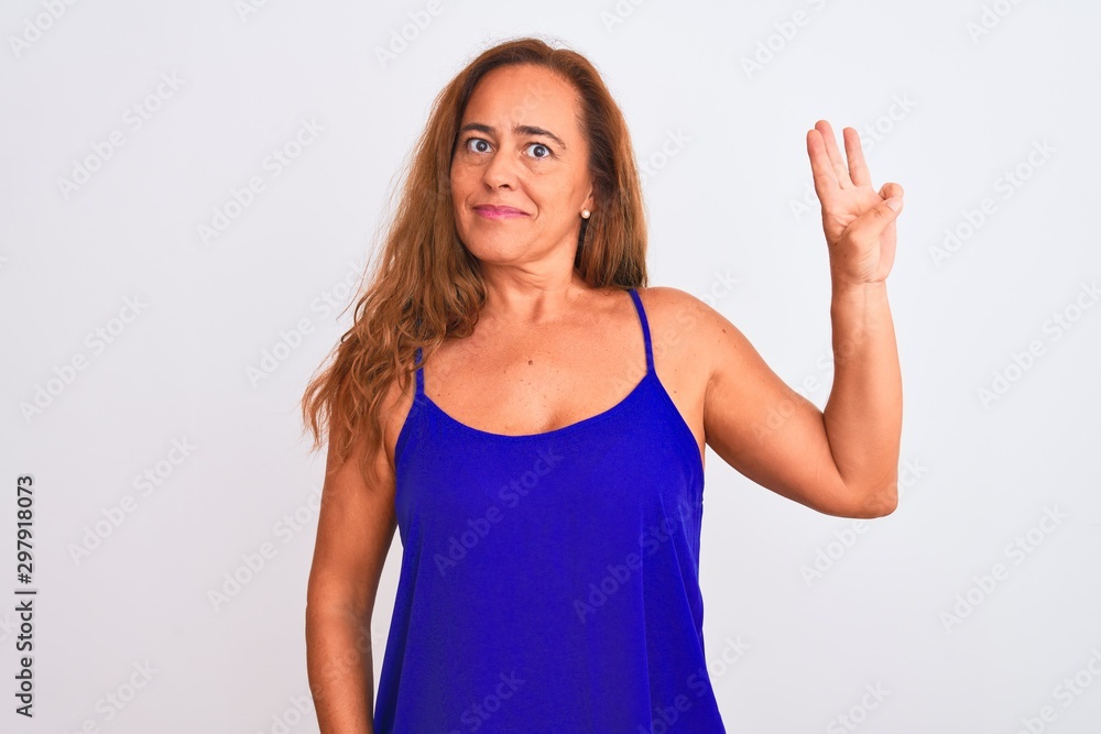 Fototapeta premium Middle age mature woman standing over white isolated background showing and pointing up with fingers number three while smiling confident and happy.