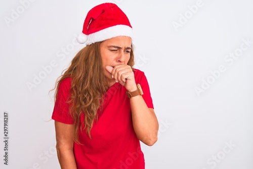Middle age mature woman wearing christmas hat over isolated background feeling unwell and coughing as symptom for cold or bronchitis. Healthcare concept.