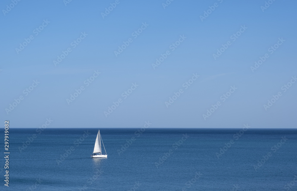 Sailboat lost in the sea on a sunny day