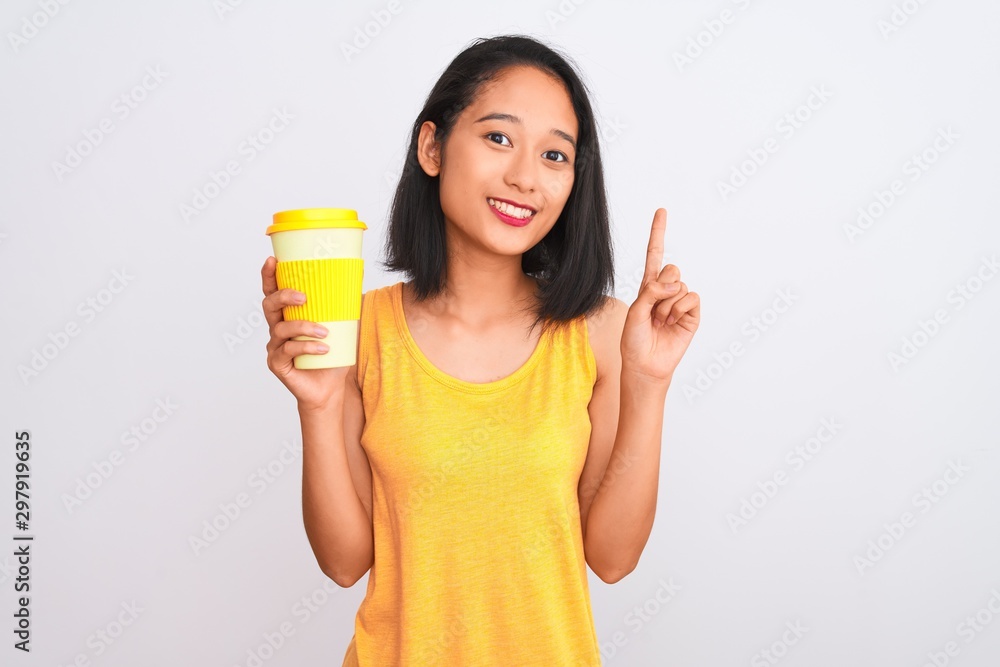 Young chinese woman drinking take away glass of coffee over isolated white background surprised with an idea or question pointing finger with happy face, number one Young chinese woman drinking take away glass of coffee over isolated white background surprised with an idea or question pointing finger with happy face, number one