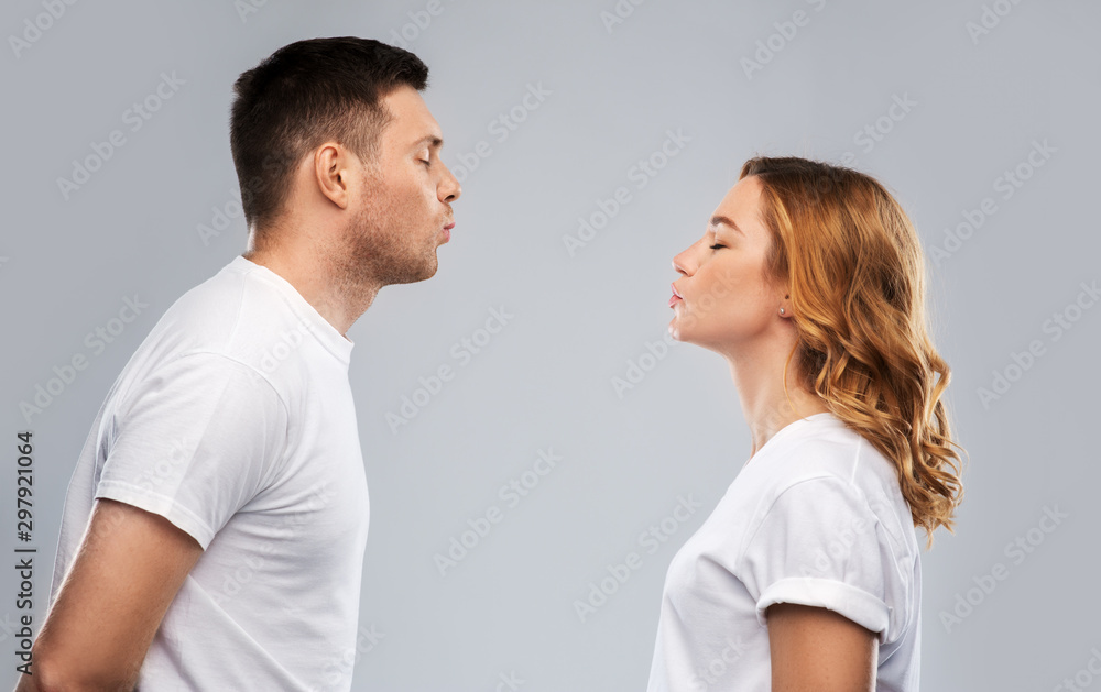 love, valentines day and relationships concept - portrait of happy couple in white t-shirts ready for kiss over grey background love, valentines day and relationships concept - portrait of happy couple in white t-shirts ready for kiss over grey background