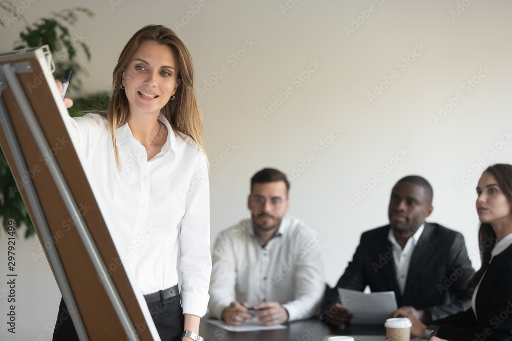 Businesswoman coach speaker drawing on flip chart giving business presentation Businesswoman coach speaker drawing on flip chart giving business presentation