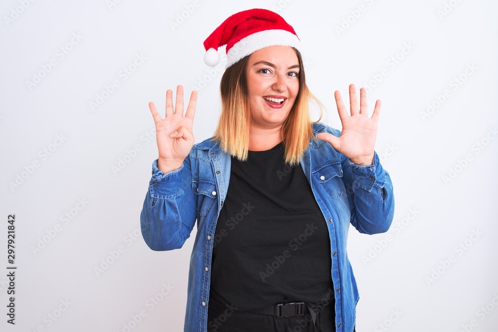 Young beautiful woman wearing Christmas Santa hat standing over isolated white background showing and pointing up with fingers number nine while smiling confident and happy. Young beautiful woman wearing Christmas Santa hat standing over isolated white background showing and pointing up with fingers number nine while smiling confident and happy.