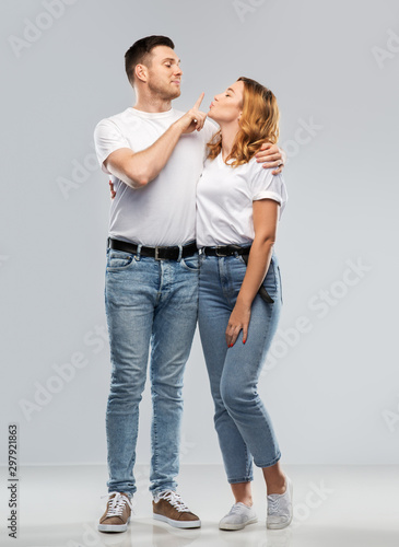 love, valentines day and relationships concept - portrait of happy couple in white t-shirts ready for kiss over grey background