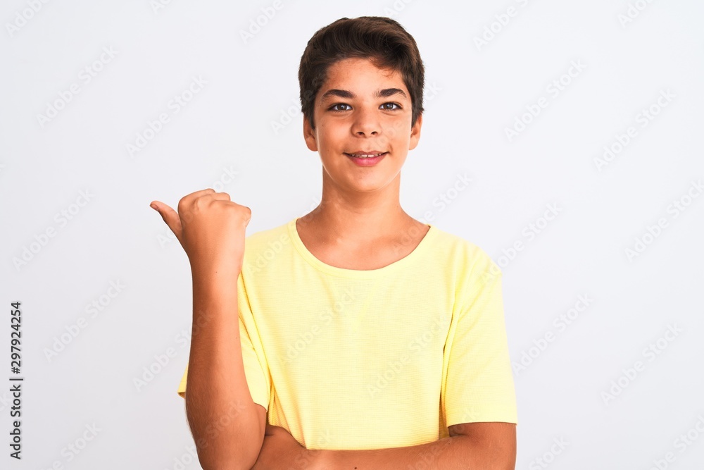 Handsome teenager boy standing over white isolated background smiling with happy face looking and pointing to the side with thumb up. Handsome teenager boy standing over white isolated background smiling with happy face looking and pointing to the side with thumb up.