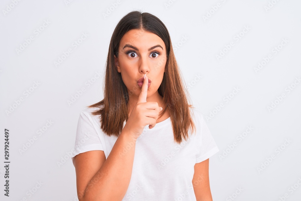 Portrait of beautiful and young brunette woman standing over isolated white background asking to be quiet with finger on lips. Silence and secret concept. Portrait of beautiful and young brunette woman standing over isolated white background asking to be quiet with finger on lips. Silence and secret concept.