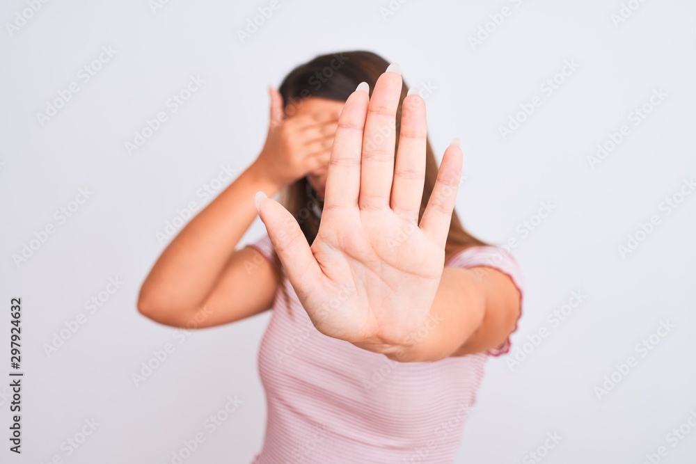 Portrait of beautiful young woman standing over isolated white background covering eyes with hands and doing stop gesture with sad and fear expression. Embarrassed and negative concept. Portrait of beautiful young woman standing over isolated white background covering eyes with hands and doing stop gesture with sad and fear expression. Embarrassed and negative concept.