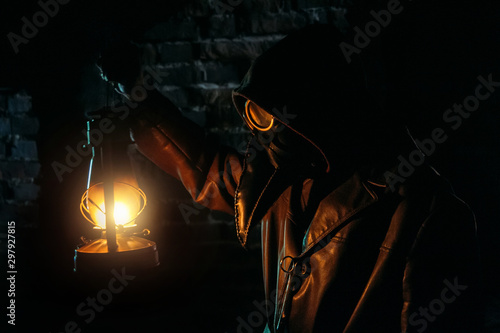Terrible plague doctor with kerosene lamp. Masked maniac. Halloween and horror concept