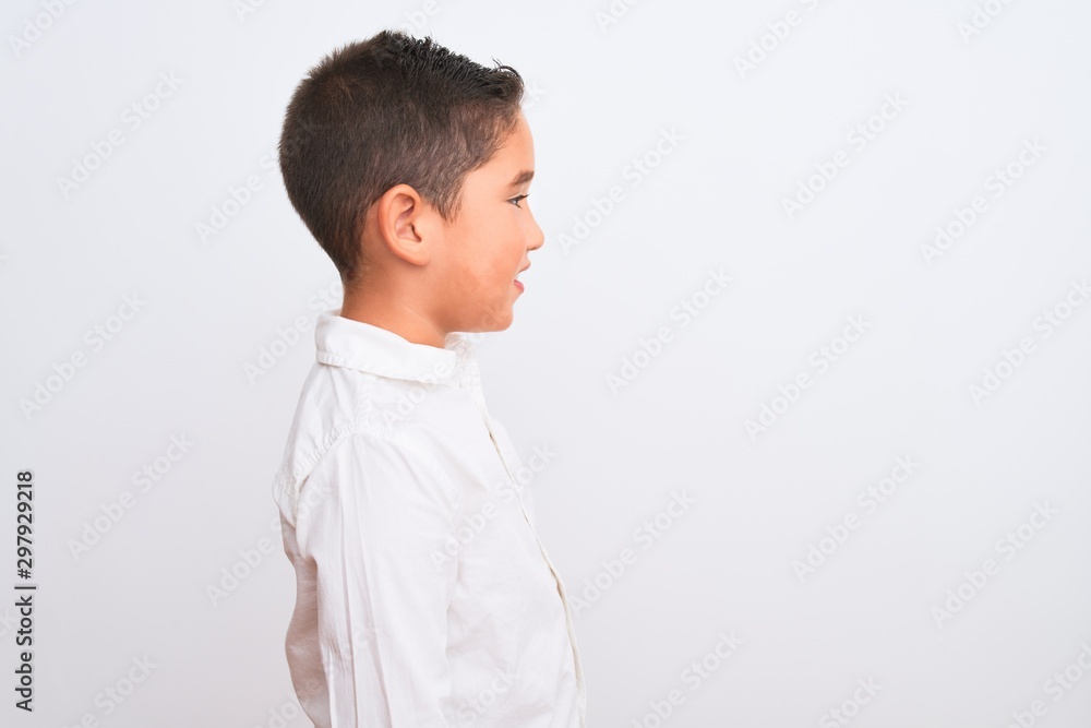 Beautiful kid boy wearing elegant shirt standing over isolated white background looking to side, relax profile pose with natural face with confident smile. Beautiful kid boy wearing elegant shirt standing over isolated white background looking to side, relax profile pose with natural face with confident smile.