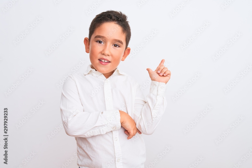 Beautiful kid boy wearing elegant shirt standing over isolated white background with a big smile on face, pointing with hand and finger to the side looking at the camera. Beautiful kid boy wearing elegant shirt standing over isolated white background with a big smile on face, pointing with hand and finger to the side looking at the camera.