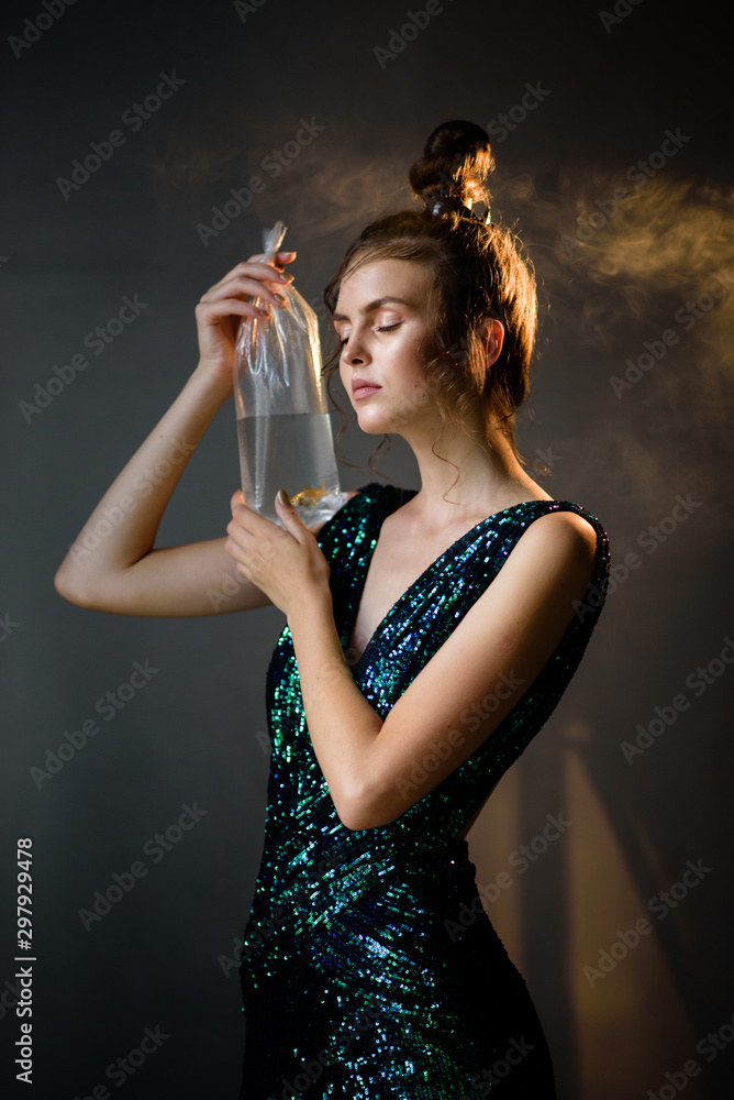 Naklejka premium Young woman with smoke and movie light in a dark room