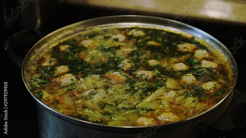 Preparation of cabbage soup with meatballs and vegetables in a metal pan