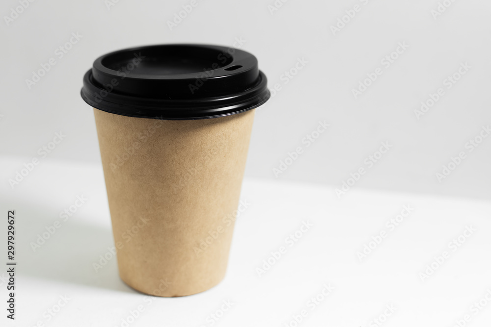 Close-up of disposable paper cup for coffee take away, with black lid, isolated on white background. Close-up of disposable paper cup for coffee take away, with black lid, isolated on white background.