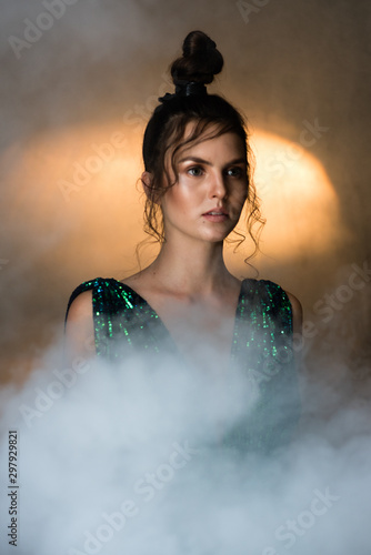 Young woman with smoke and movie light in a dark room