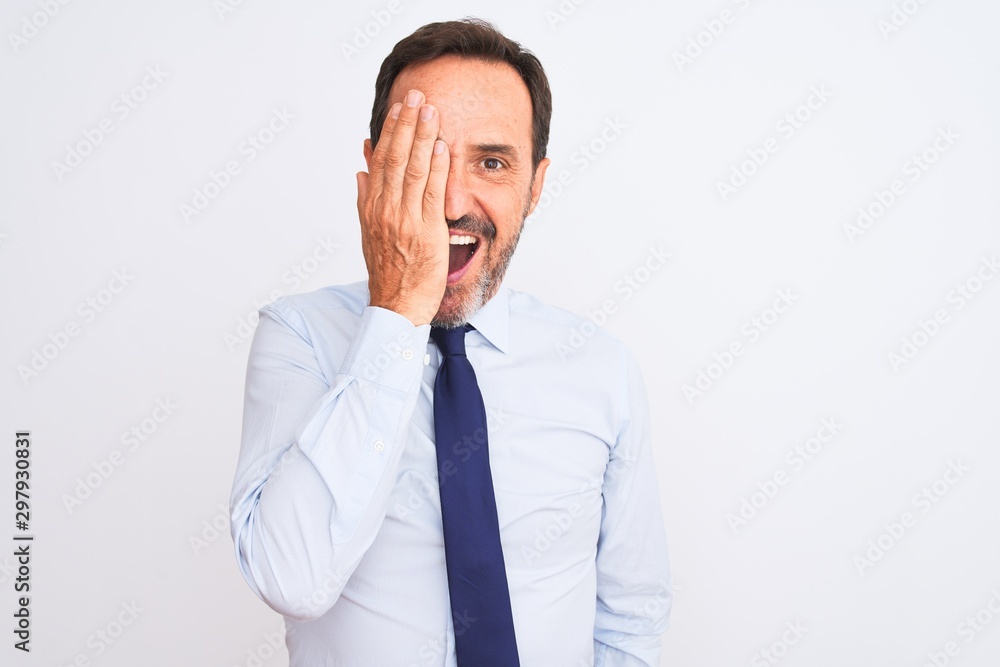 Middle age businessman wearing elegant tie standing over isolated white background covering one eye with hand, confident smile on face and surprise emotion. Middle age businessman wearing elegant tie standing over isolated white background covering one eye with hand, confident smile on face and surprise emotion.