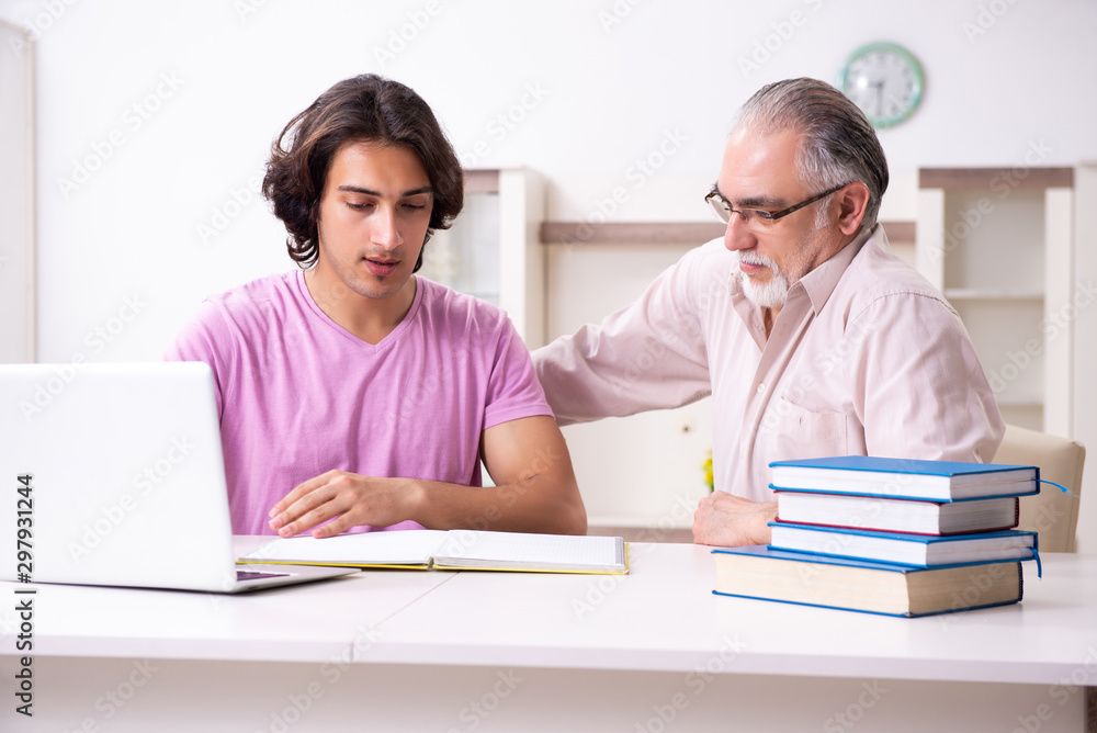 Old father helping his son in exam preparation Old father helping his son in exam preparation