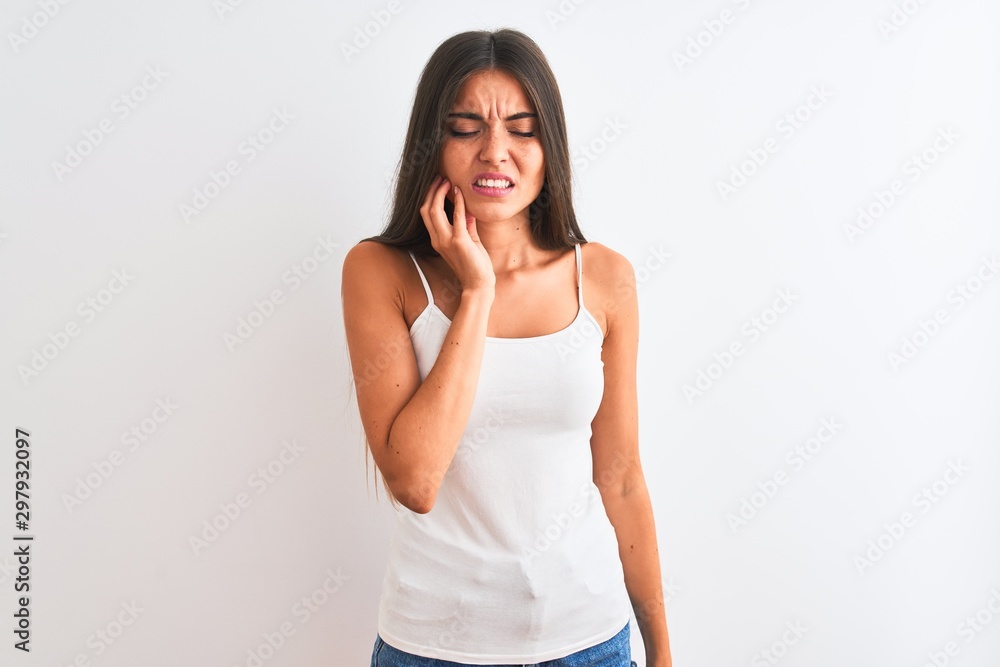 Young beautiful woman wearing casual t-shirt standing over isolated white background touching mouth with hand with painful expression because of toothache or dental illness on teeth. Dentist concept. Young beautiful woman wearing casual t-shirt standing over isolated white background touching mouth with hand with painful expression because of toothache or dental illness on teeth. Dentist concept.